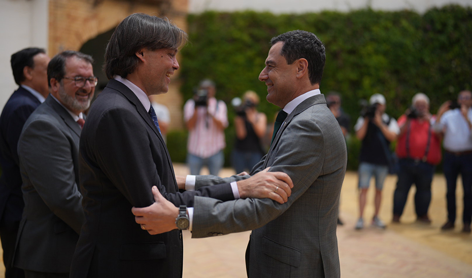 El presidente andaluz, Juanma Moreno, saluda al rector de la Universidad Pablo de Olavide, Francisco Oliva.