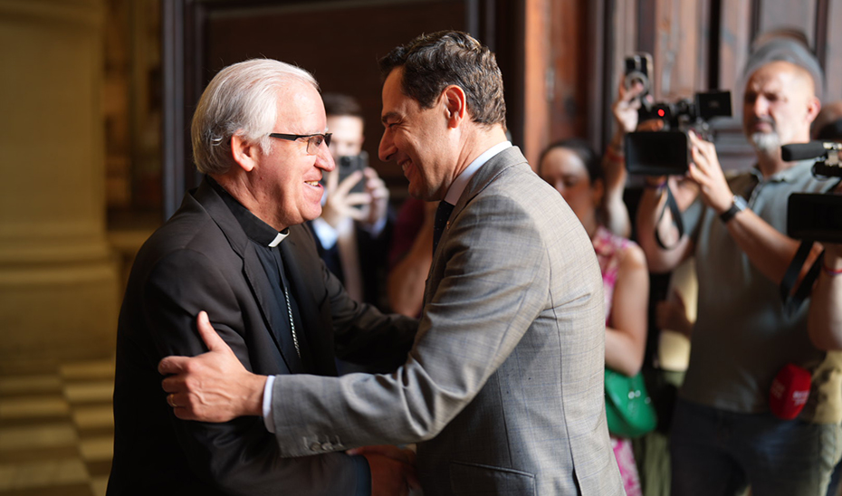 El presidente de la Junta de Andalucía, Juanma Moreno, saluda al arzobispo de Sevilla, José Ángel Saiz Meneses.
