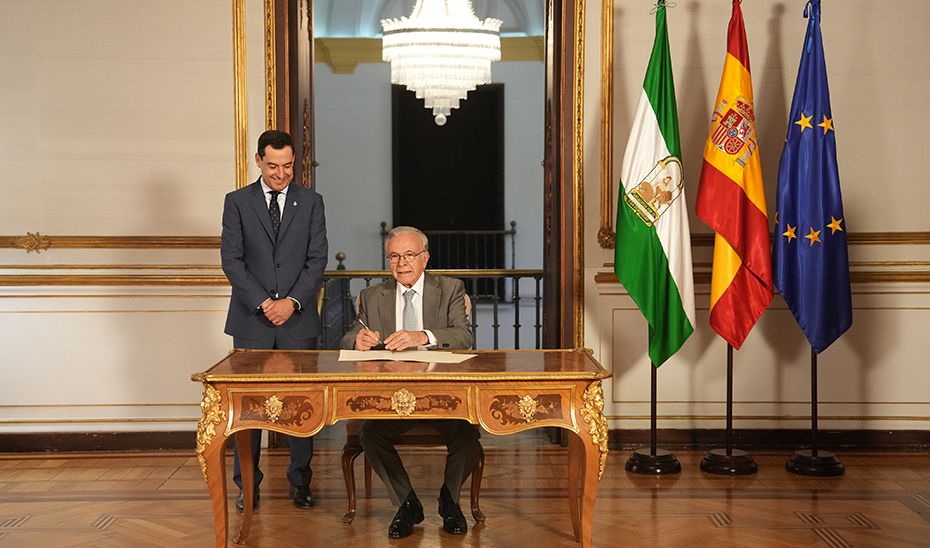 Fainé estampa su firma en el convenio entre la Junta de Andalucía y la Fundación 'la Caixa' en presencia del presidente Juanma Moreno.