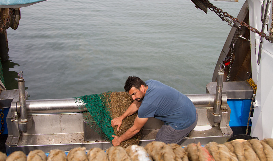 Un pescador faenando en su embarcación.