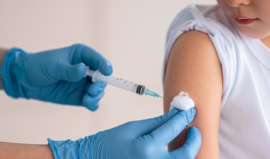 Un profesional sanitario dispensa la vacuna frente a la meningitis a un menor.
