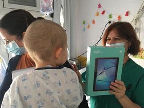 Profesional entrega una tablet a un niño durante su estancia