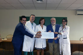 Responsables del hospital y el IMIBIC recepcionan el cheque que entrega la Federación de Peñas