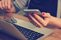 mano de mujer con móvil y teclado